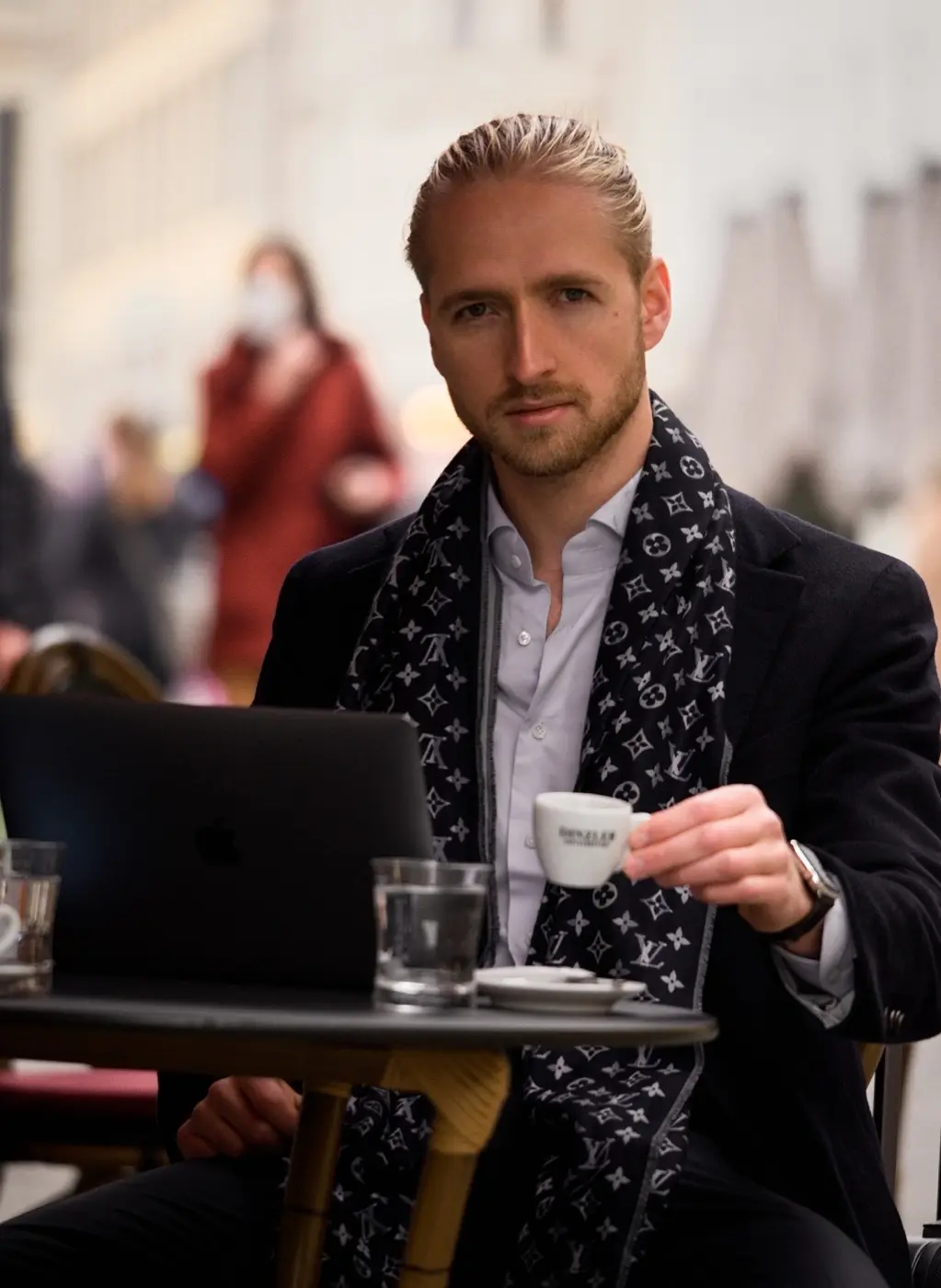 Mann mit Espresso und Laptop in einem Wiener Straßencafé