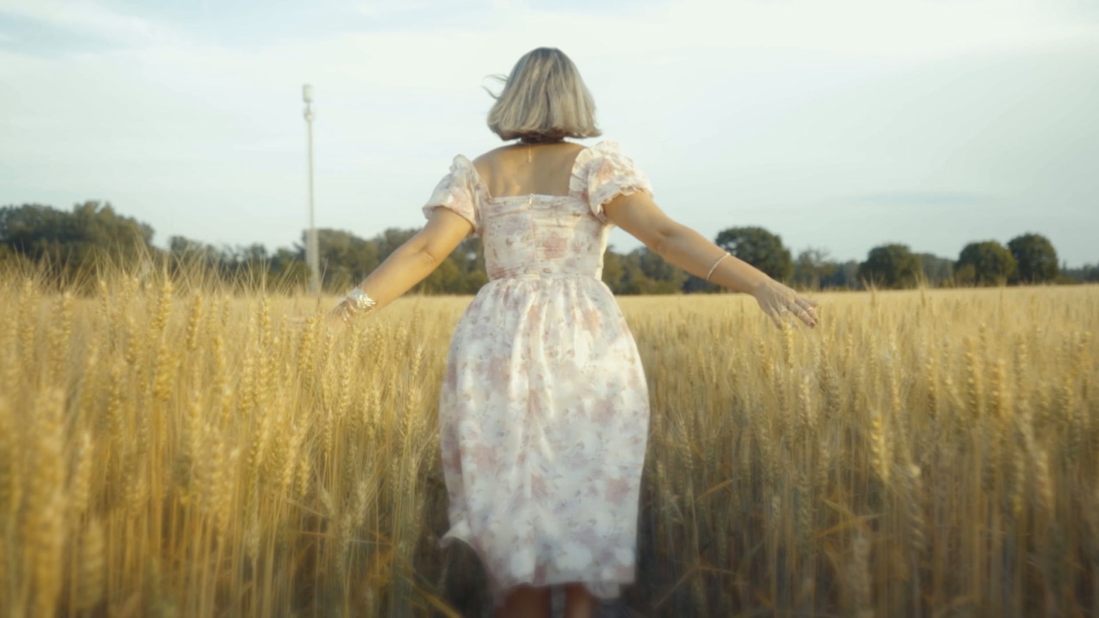 Fashion Film von Alex Kardos: Frau im Sommerkleid läuft durch ein Weizenfeld