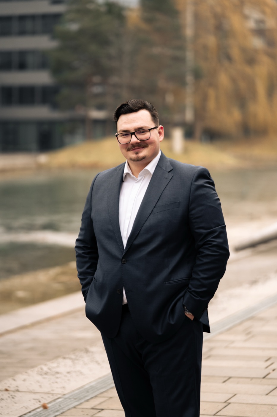 Businessportrait eines Mannes mit Brille am Wasser